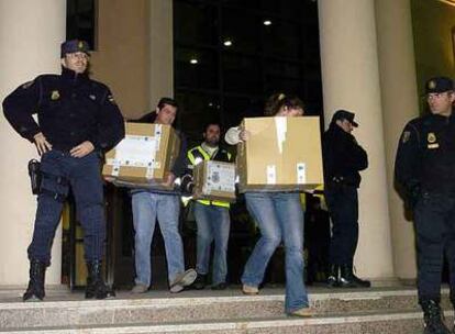 Agentes de policía sacan cajas con documentación tras un registro del Ayuntamiento de Los Alcázares.