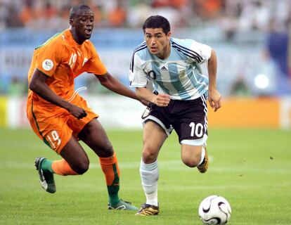 Yaya Touré persiguiendo al argentino Juan Román Riquelme en el partido que enfrentó a las selecciones de Costa de Marfil y Argentina de la fase de grupos del Mundial 2006.