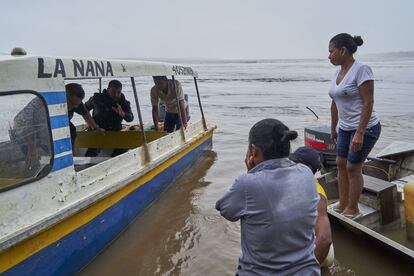 Lilia e Karina aguardam que membros de um abrigo de animais venham buscar um peixe-boi que encontraram encalhado na margem do rio Amazonas, para transportá-lo para suas instalações na cidade de Letícia.