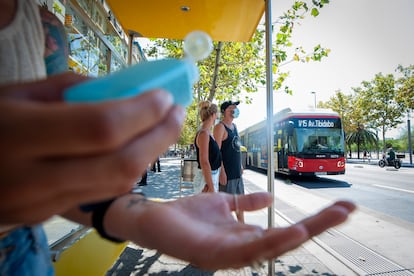 A person applies hand sanitizer at a bus stop in Barcelona.