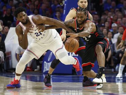 Joel Embiid pugna por la pelota con Kawhi Leonard