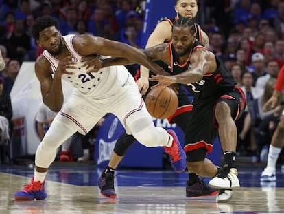 Joel Embiid pugna por la pelota con Kawhi Leonard