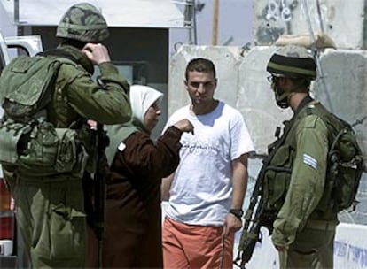 Una mujer palestina discute con soldados israelíes.
