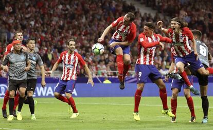 El lateral del Atlético de Madrid Juanfran (3-d) cabecea un balón.