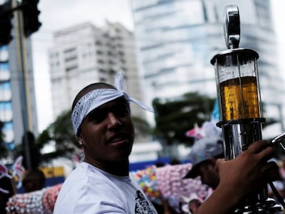 Folião leva cerveja em uma mini bomba de gasolina, sábado em São Paulo.