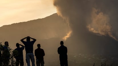 Residents look from a hill as lava continues to flow from the volcano on the island of La Palma.