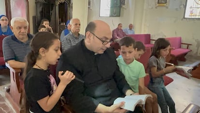 Der argentinische Priester Gabriel Romanelli mit zwei Kindern in der Kirche in Gaza im Mai.