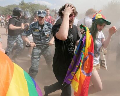Dos activistas huyen en la marcha del Orgullo Gay en San Petersburgo tras la intervención de la policía.