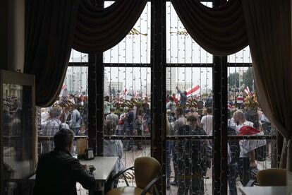 Un hombre toma un café mientras observa la manifestación, en un local del centro de Minsk. 