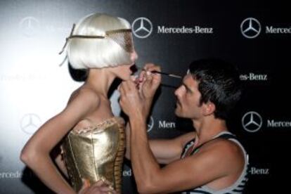 Un maquillador prepara a una de las modelos para el desfile en la Cibeles Madrid Fashion Week.