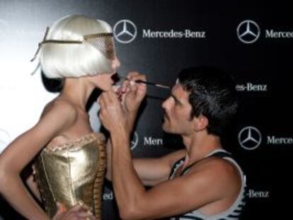 Un maquillador prepara a una de las modelos para el desfile en la Cibeles Madrid Fashion Week.