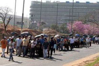 Los choferes paraguayos crucificados en protesta por sus despidos fueron registrados este martes al ser trasladados en carritos por las calles de la localidad de Luque, a 15 kilómetros de Asunción (Paraguay).