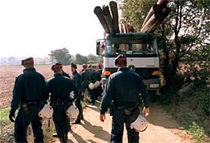 Una dotación de los Mossos d'Esquadra protege uno de los camiones de la obra.