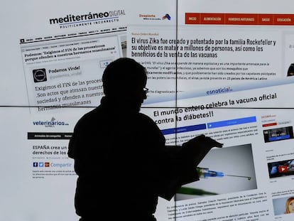 Un hombre observa varias web que muestran noticias falsas. 