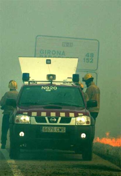 Un coche de los Mossos d?Esquadra, en la N-II, que resultó cortada a causa del fuego.