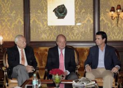 El rey Juan Carlos, junto al ministro de Asuntos Exteriores, José Manuel García-Margallo (i), y el ministro de Industria, Energía y Turismo, José Manuel Soria (d), durante la conversación que ha mantenido hoy, antes de emprender viaje de regreso a España, con los periodistas que han cubierto su visita oficial a la India, en la que ha dicho que considera "muy productivo" para los intereses españoles el resultado de su visita y se muestra convencido de que, en las negociaciones europeas frente a la crisis, España saldrá adelante "con el cuchillo en la boca" y con "una sonrisa".