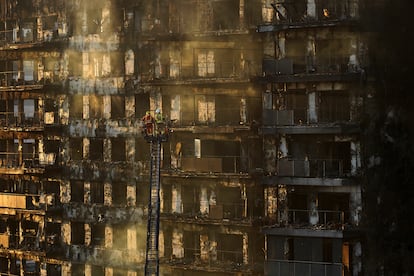 Bomberos trabajan en el edificio de bloques incendiado en Valencia, este viernes.