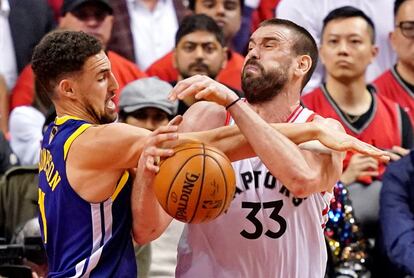 El jugador de Golden State Warriors Klay Thompsonn y el de Toronto Raptors Marc Gasol luchan por un rebote.