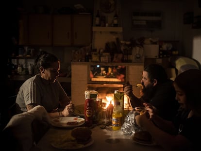 Rocío y su marido Jesús, junto a Jonny, el hijo menor, cenan en su domicilio de la Cañada Real a la luz la lumbre.