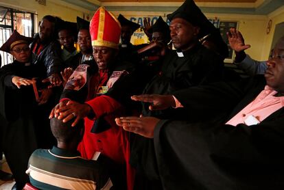 El líder de la Iglesia de Gabola, el autoproclamado papa Tsietsi Makiti, unge con cerveza a un recién llegado a la comunidad durante un servicio.