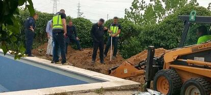 Policías nacionales registran el jardín del chalé del principal detenido.