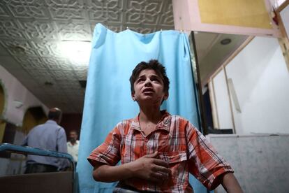 TOPSHOT - A injured Syrian boy cries as he awaits treatment at the makeshift clinic following a reported  air stike on the rebel-held town of Douma, east of the capital Damascus, on August 18, 2016. 
More than 290,000 people have been killed and millions forced to flee their homes since Syria's conflict erupted in March 2011.
 / AFP PHOTO / Abd Doumany