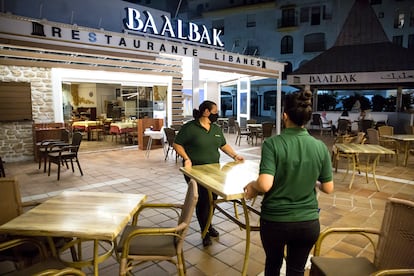 Dos empleadas recogen la terraza del restaurante Baalbak, en Puerto Banús.
