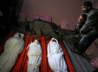 Parientes de tres niños de una misma familia, muertos en el bombardeo israelí contra Rafah, lloran junto a los cadáveres.