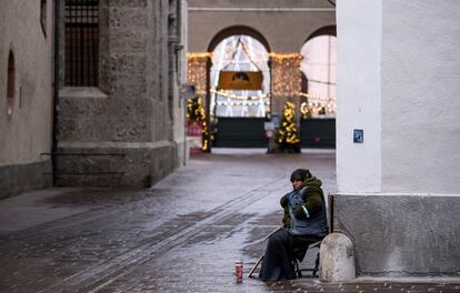 Una mujer pide limosna cerca de un mercadillo navideño en Salzburgo. Es posible ir al médico y a los centros de vacunación y test de covid, o hacer "uso de los instrumentos de la democracia", como la participación en manifestaciones.