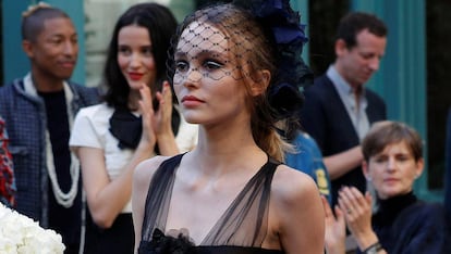 Actress Lily-Rose Depp presents a creation with a Paris Cosmopolite theme by designer Karl Lagerfeld during the Metiers D&#8217;Art Show for Chanel fashion house in Paris