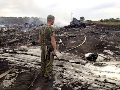 Un rebelde prorruso observa los restos del avión de Malaysia Airlines. 