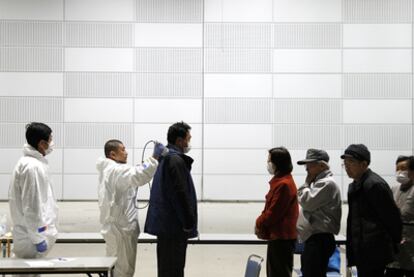 Un grupo de personas se somete a un examen de detección de radiactividad en Koriyama, a 80 kilómetros de Fukushima.