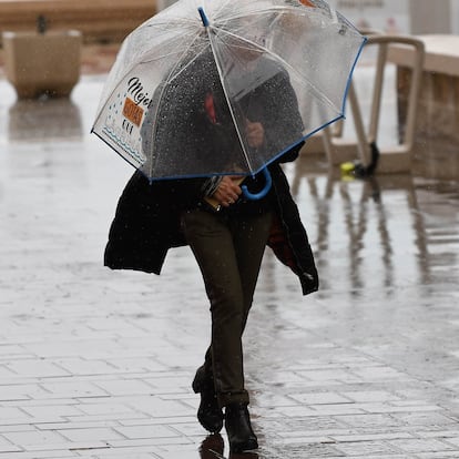 GRAFAND6739. ALMERÍA, 05/03/2025.-Una persona se resguarda con un paraguas de la lluvia que cae en Almería. La Junta de Andalucía mantiene activado desde la pasada medianoche el plan de emergencia por riesgo de inundaciones, en fase de preemergencia, ante la previsión de lluvias en la comunidad autónoma este miércoles. EFE/Carlos Barba
