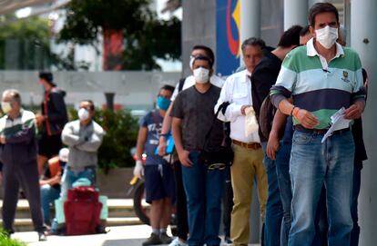 Un grupo de hombres hace fila para entrar a un banco en su día de 'Pico y Género'.