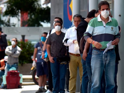 Un grupo de hombres hace fila para entrar a un banco en su día de 'Pico y Género'.