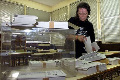 Mientras los candidatos a las elecciones autonómicas vascas agotaban las últimas horas de campaña para pedir el voto, decenas de personas se afanaban en los últimos preparativos para que todo esté listo el domingo. En la foto, una empleada municipal coloca las papeletas y prepara la urna en el Colegio Público Basurto de Bilbao.