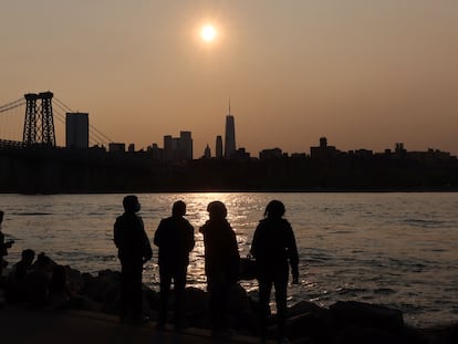 Un grupo de personas observa el atardecer desde Manhattan (Nueva York) donde se observa la bruma.