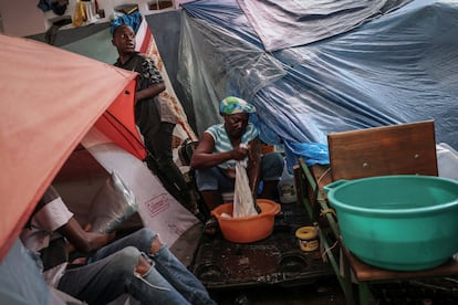 Para huir de los enfrentamientos entre la coalición de bandas que controla la mayor parte de Puerto Príncipe y la policía, los residentes se refugian en campamentos improvisados en las escuelas de la ciudad, en los que viven en malas condiciones. En la imagen, Mirriam Auge, de 45 años, lavaba la ropa en la escuela Darius Denis, el 5 de mayo. "No podemos hacer nada, no hay dinero ni comercio", decía Auge, que se vio obligada a abandonar su casa tres meses antes. "Lo perdimos todo en nuestras casas. Lloré mientras todos dormían". 