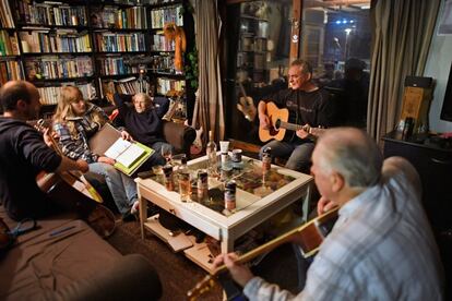 Los residentes Stuart Taylor, Penny Grear, Sheila Grear, Davie Wilson y Jim Grear tocan música y disfrutan de una bebida en una reunión nocturna en Foula.