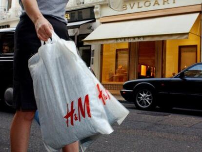 Una mujer con bolsas de H&M pasea por la calle comercial Bond street (Londres).