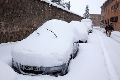 Coches cubiertos por la nieve caída durante el temporal que afecta a Ávila. 