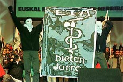 Dos encapuchados muestran una pancarta de ETA en un acto de Gestoras pro Amnistía en 1999.