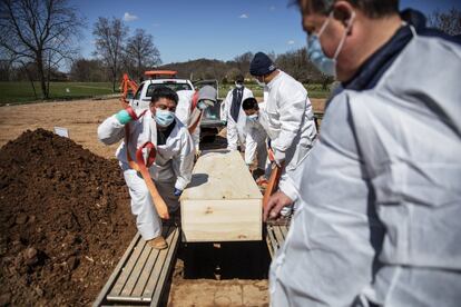 Sepultureros bajan el ataúd de alguien que murió de coronavirus en el cementerio de la Asociación Hebrea de Entierro Libre en el distrito de Staten Island de Nueva York, en abril de 2020.