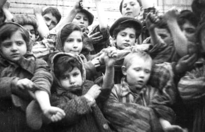 Algunos de los 600 niños supervivientes del campo de concentración de Auschwitz muestran los números de identificación tatuados en sus brazos, el día de su liberación.
