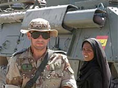 Un soldado español camina junto a una mujer en Diwaniya.