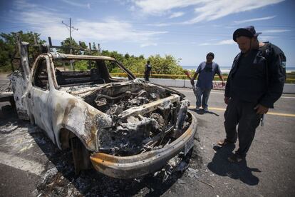 Miembros de la Fuerza Rural observan los restos de un vehículo incendiado durante los disturbios del pasado domingo 19 de julio.