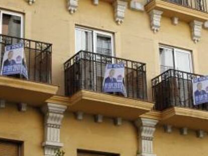 Anuncios de venta de viviendas en los balcones de un edificio de una calle de Madrid.