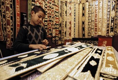 Un adolescentes trabaja en una tienda de alfombras en Marruecos.