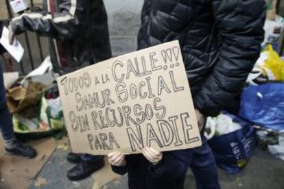 Un niño sujeta una pancarta en la concentración de vecinos del lunes para pedir a los políticos que actúen ante la emergencia social.