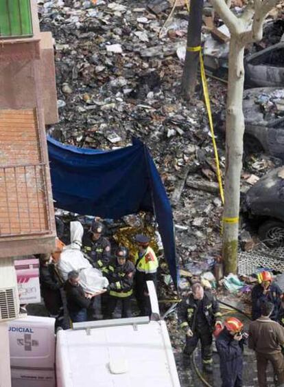 Los bomberos evacúan el cuerpo de una de las vícitimas de la explosiones de ayer